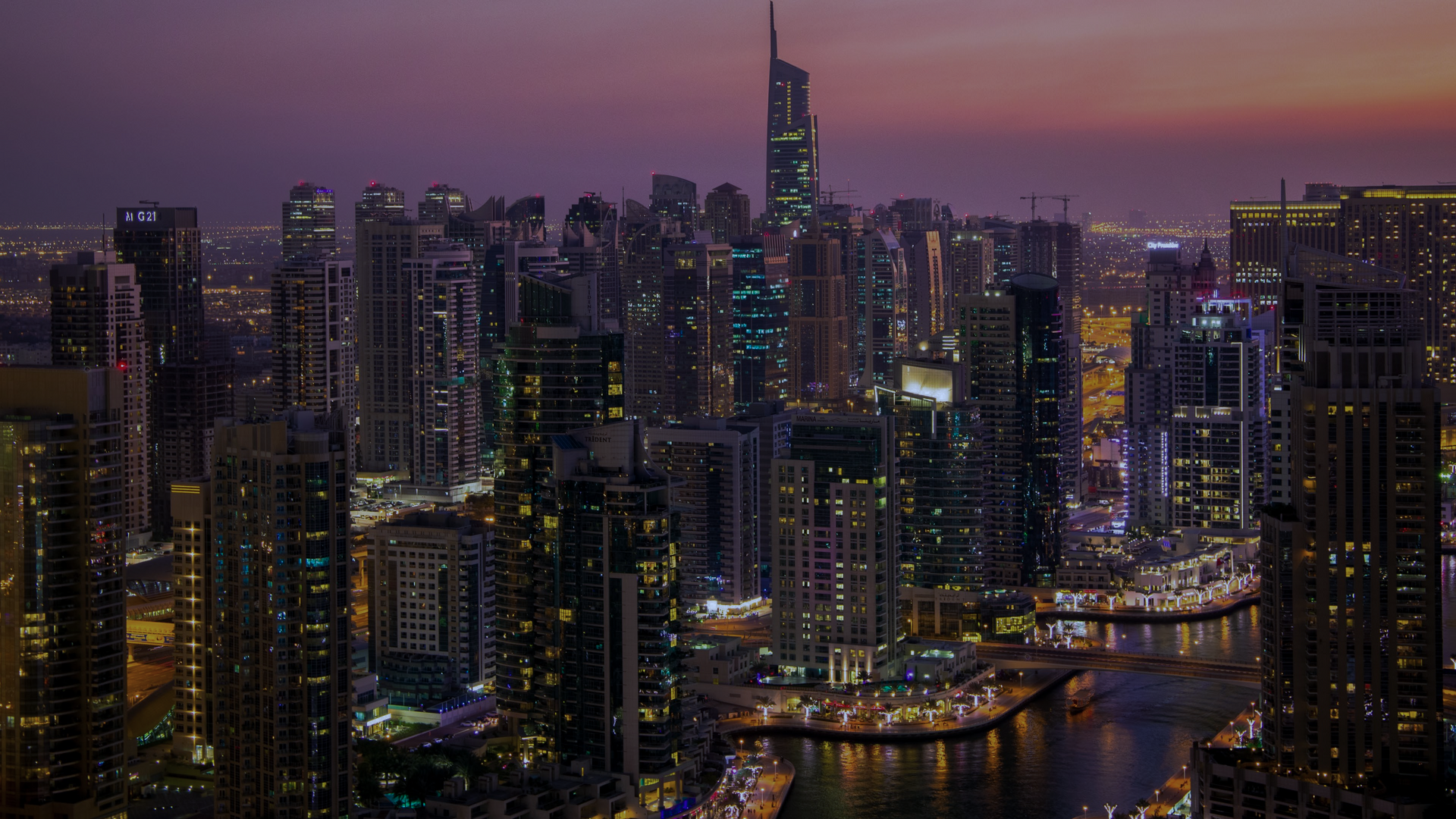 A city skyline with many tall buildings and a body of water